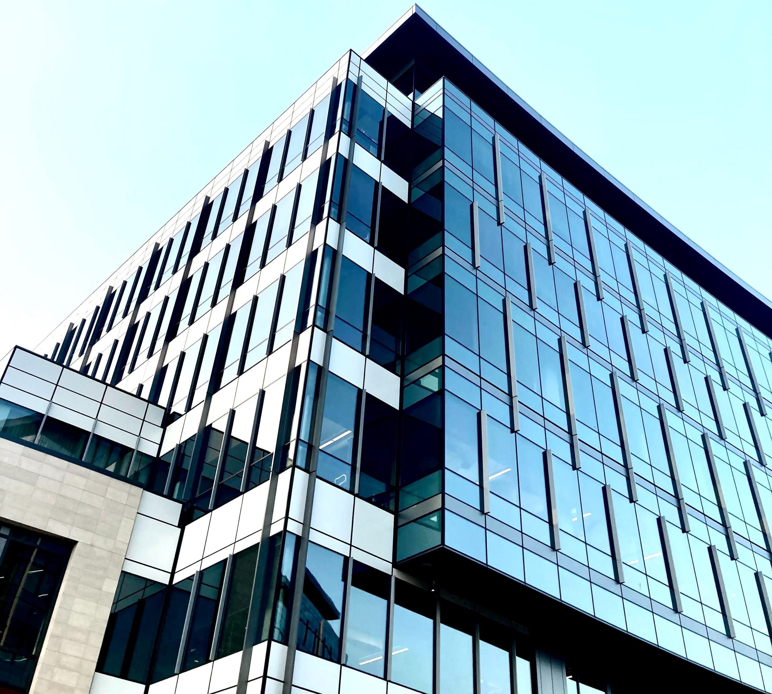 looking up at glass building and blue sky